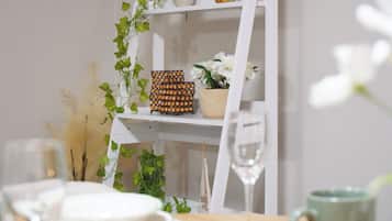 A white shelf with decorative items including a golden bird, a potted plant, and a wall-mounted decorative piece.