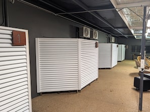 A storage area with metal shutters, a number sign, and industrial fans.