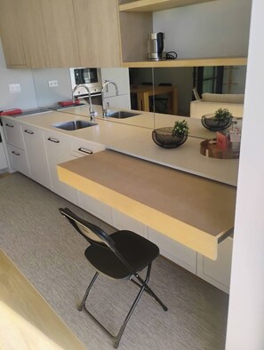Una cocina moderna con una isla central, un lavamanos y una cafetera.