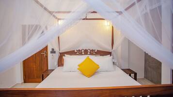 A bed with a canopy, wooden headboard, and white bedding.