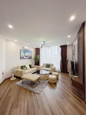 Una sala de estar moderna con un juego de sofá, una mesita de centro y un televisor de pantalla plana.