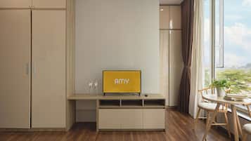 Habitación moderna con televisor integrado, piso de madera y vista a través de un ventanal grande.