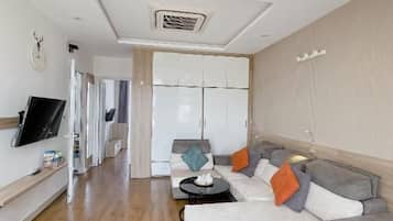 Een moderne woonkamer met een bank, een salontafel en een flatscreen-televisie.