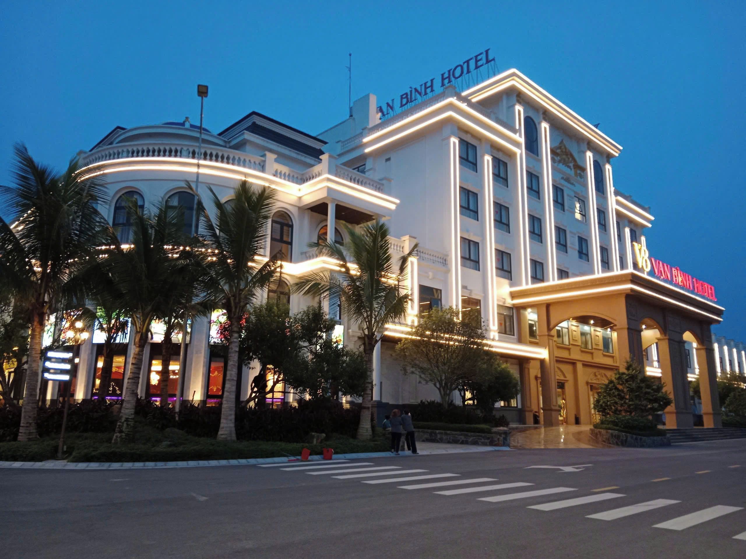 A hotel with a prominent sign, a large entrance, and a well-lit facade.