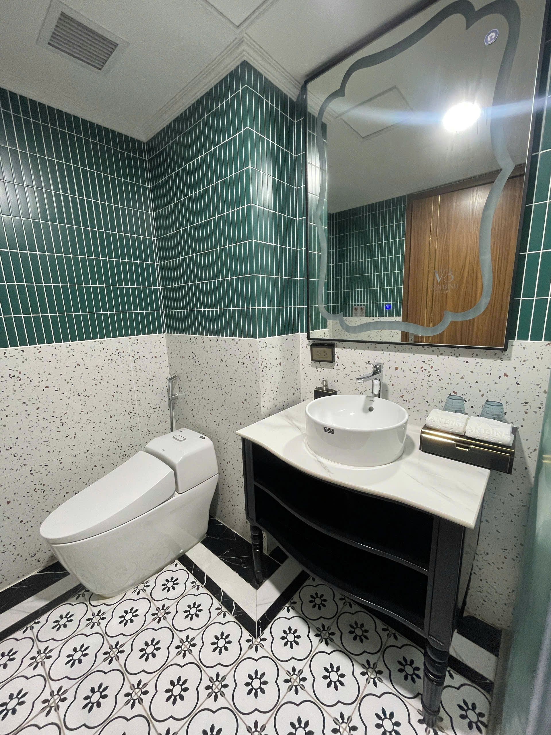 A bathroom with a white toilet, a sink with a mirror, and a shower area.