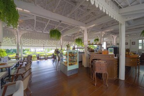A spacious indoor area with wooden flooring, a central counter, and hanging plants. - InterCon 1 Bedroom with Seaview(IR142) (Hua Hin)