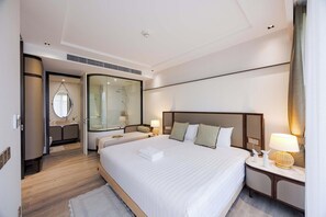A hotel room with a large bed, a separate bathroom with a glass shower enclosure, a bedside table with a lamp, and a mirror. - InterCon 1 Bedroom with Seaview(IR142) (Hua Hin)