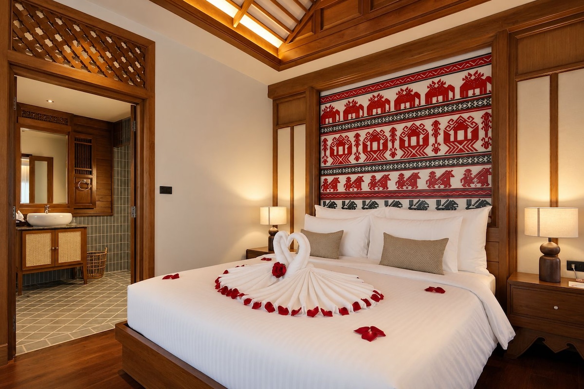A hotel room with a large bed, wooden headboard, and a decorative wall panel.