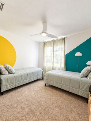 A room with two beds, a ceiling fan, a window with curtains, and a wall with a cloud decoration. - Private Pool, RV Port, Movie Screen and more! Bring the Whole Family! (Lakeland)