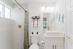 Un baño moderno con ducha, inodoro y lavamanos.