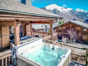 A wooden cabin with a hot tub and a deck overlooking a mountainous landscape. - Chalet Cerf, Sleeps 10, Hot Tub, Ascension Immobilier (LA COTE D ARBROZ)