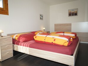Ein Schlafzimmer mit einem Bett, Nachttischen und einem Beistelltisch.