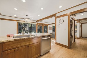 A modern kitchen with a granite countertop, stainless steel sink, and built-in dishwasher. - NEW Gated Tahoe City Ski Condo, Pier & Fireplace (Tahoe City)