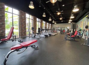 A gym with exercise equipment, large windows, and a brick wall. - Sunshine Hideaway Near Disney • Resort Pool • Family-Friendly 3BR (Davenport)