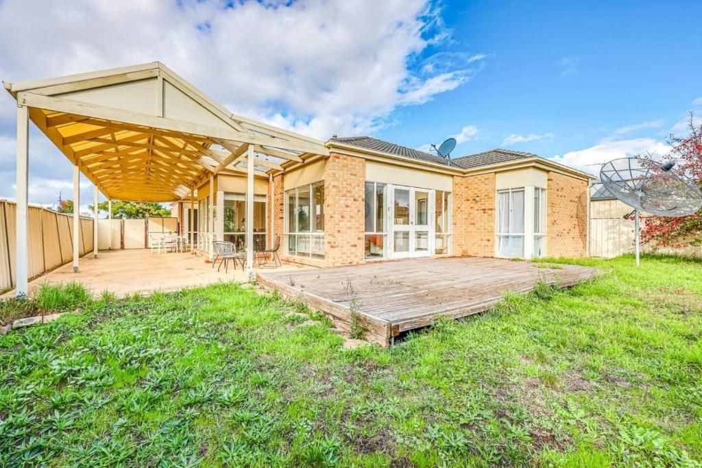 A house with a covered patio, a brick exterior, and satellite dishes.