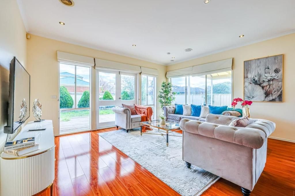 A spacious living room with a sofa, a coffee table, and a television.