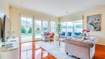 A spacious living room with a sofa, a coffee table, and a television.