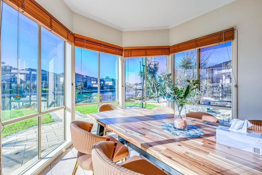 Ein moderner Essbereich mit einem großen Tisch, mehreren Stühlen und Blick auf die Stadt durch große Fenster.