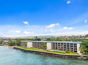 Un hôtel situé sur la côte, doté de nombreux balcons, d’une piscine et offrant une vue sur la plage et le paysage urbain.