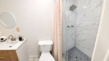 Ein Badezimmer mit Toilette, Waschbecken und Dusche.