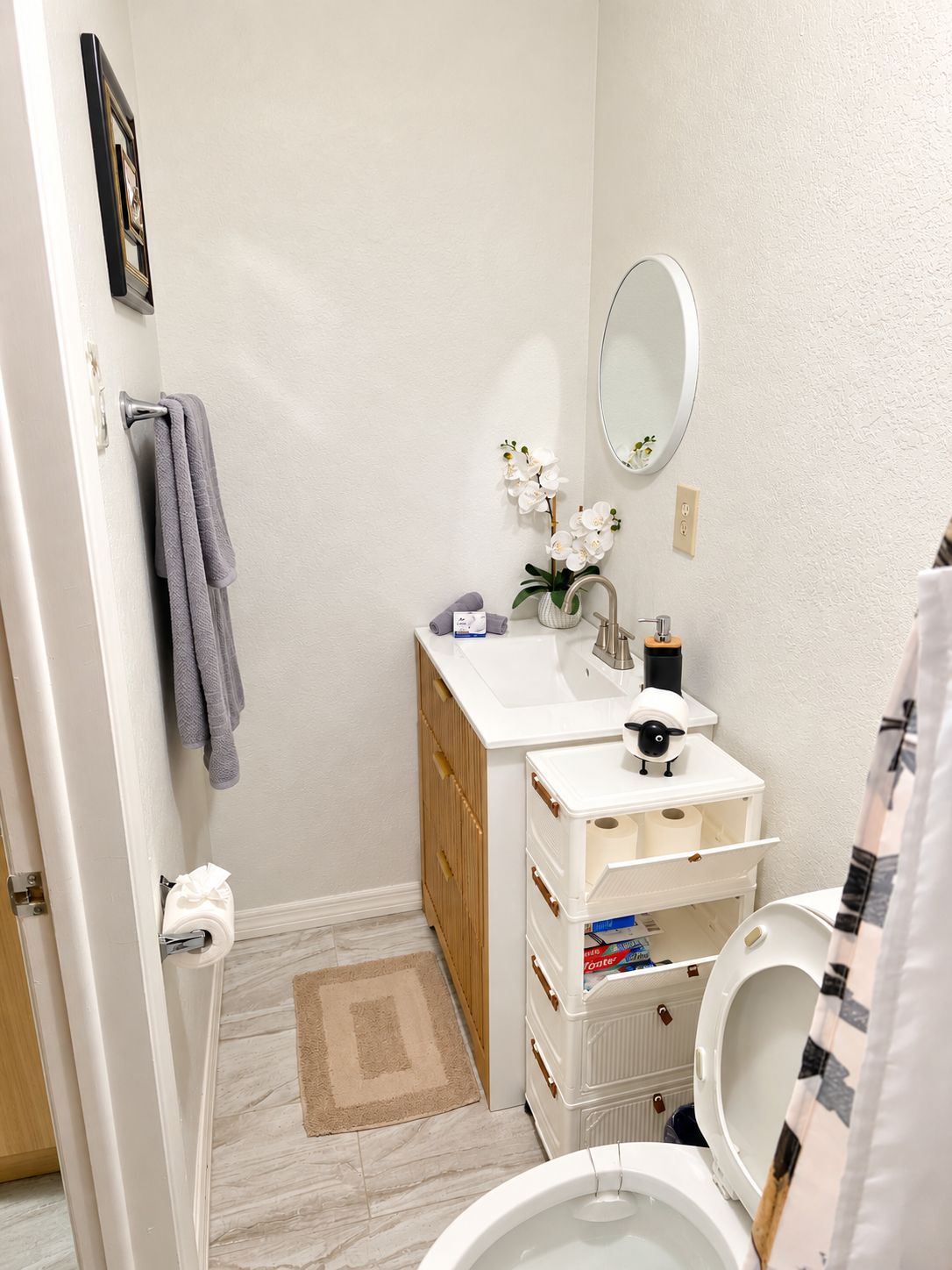 A compact bathroom with a toilet, sink, and a small cabinet.