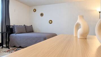 Ein Schlafzimmer mit Bett, Nachttisch, Lampe und Wanddekorationen.
