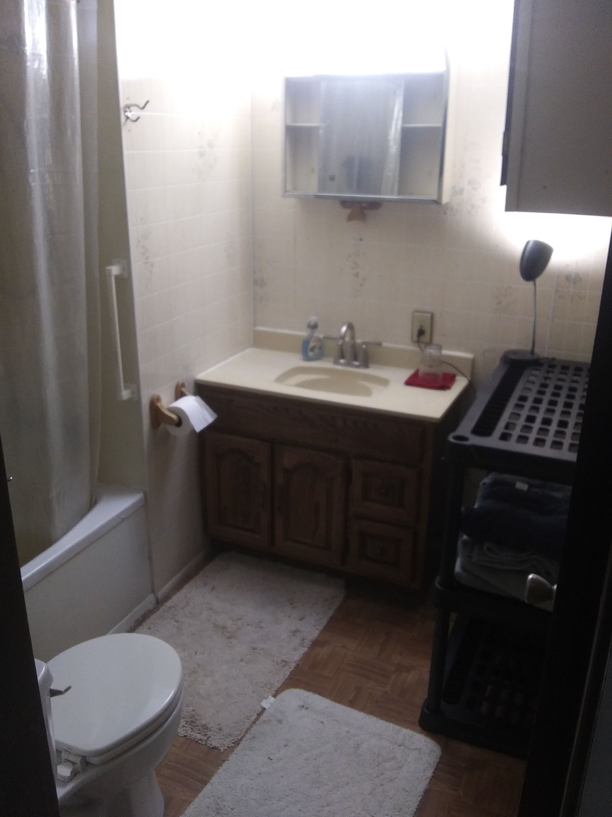 A small bathroom with a toilet, sink, and mirror.