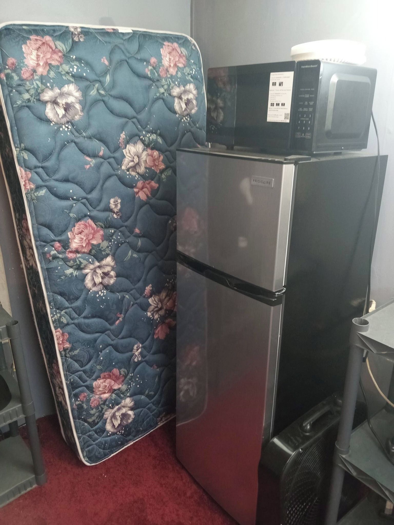 A compact kitchenette with a refrigerator and microwave.