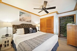 A hotel room with a bed, a ceiling fan, a nightstand, a lamp, a wardrobe, and a window with blinds. - Aloha Sunrise | AC | POOL | HOT TUB (Koloa)