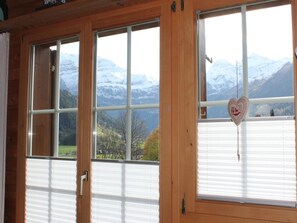 A room with three windows offering a view of snow-capped mountains. - Rottäli OG Appartement/Fewo, Dusche, WC, 2 Schlafräume 4-Bettwohnung by Interhome (Lenk)