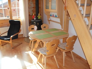A wooden dining table with four chairs, a black chair, and a wooden staircase. - Rottäli OG Appartement/Fewo, Dusche, WC, 2 Schlafräume 4-Bettwohnung by Interhome (Lenk)