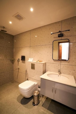 Ein modernes Badezimmer mit Toilette, Waschbecken und Dusche.