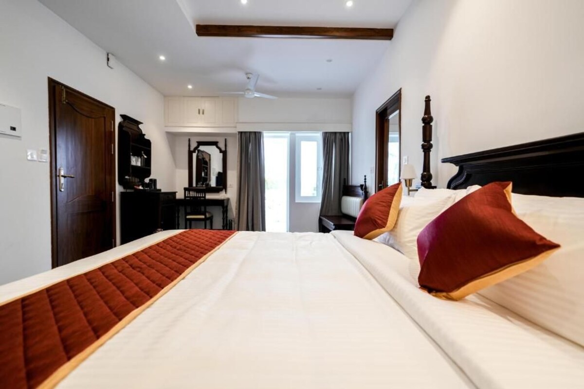 Ein Hotelzimmer mit einem großen Bett, einem Schreibtisch und einem Kleiderschrank.