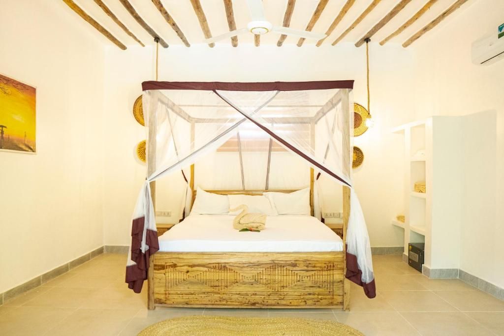 Un lit à baldaquin, un mur orné d’un tableau et une étagère avec divers objets.
