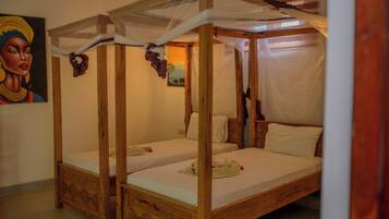 Una habitación con dos camas de madera, cada una con dosel y ropa blanca.