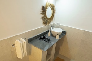 A bathroom with a sink, mirror, towel rack, and a power outlet. - Nuru ya Zanzibar Bungalow (Pongwe)