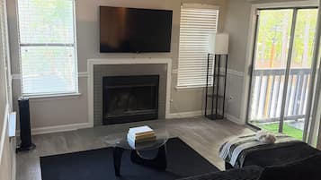 A living room with a fireplace, a flat-screen TV, and a sofa.