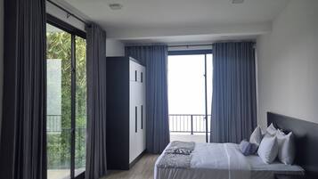 Een moderne slaapkamer met een groot bed, een kledingkast en een plafondventilator.