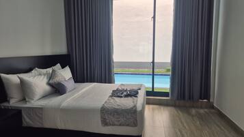 Een hotelkamer met een bed, zwembad uitzicht en een balkon.