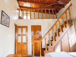 Una escalera de madera con barandilla que lleva a un nivel superior.