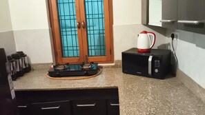 Cuina amb fornet de gas, microones i bullidor.