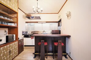 A compact kitchen with a central island, a microwave, a sink, and a chandelier.
