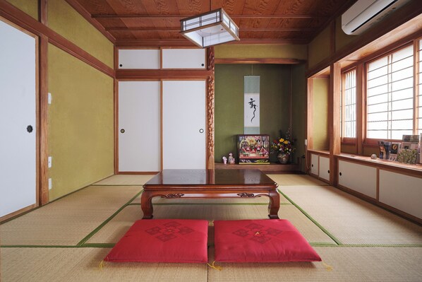 A traditional Japanese room with tatami flooring, a low wooden table, and sliding doors.