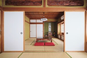 A traditional Japanese room with tatami flooring, a low wooden table, and sliding doors.