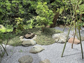 A garden with a rock arrangement, gravel path, and various shrubs.