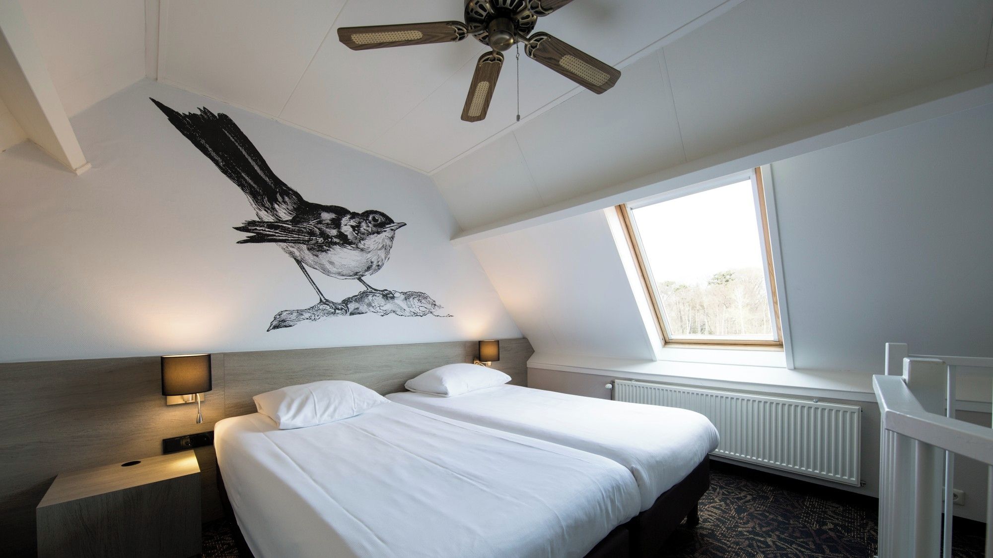 Unwind in crisp twin beds beneath charming bird mural.
