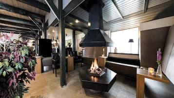 Relax fireside in plush seating with a glowing hearth.