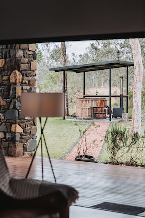 A stone wall, a wooden deck, and a rustic outdoor seating area with a fire pit.