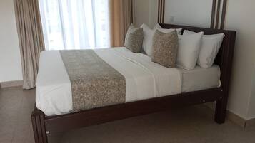A bed with a wooden frame, white bedding, and a patterned throw.