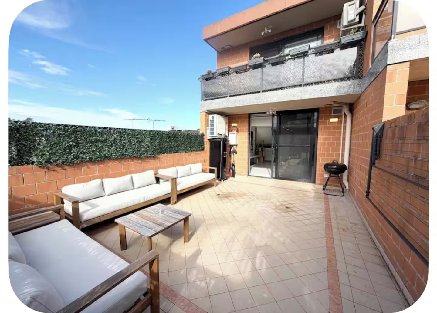 Un espace extérieur aménagé avec un canapé, une table et un barbecue.